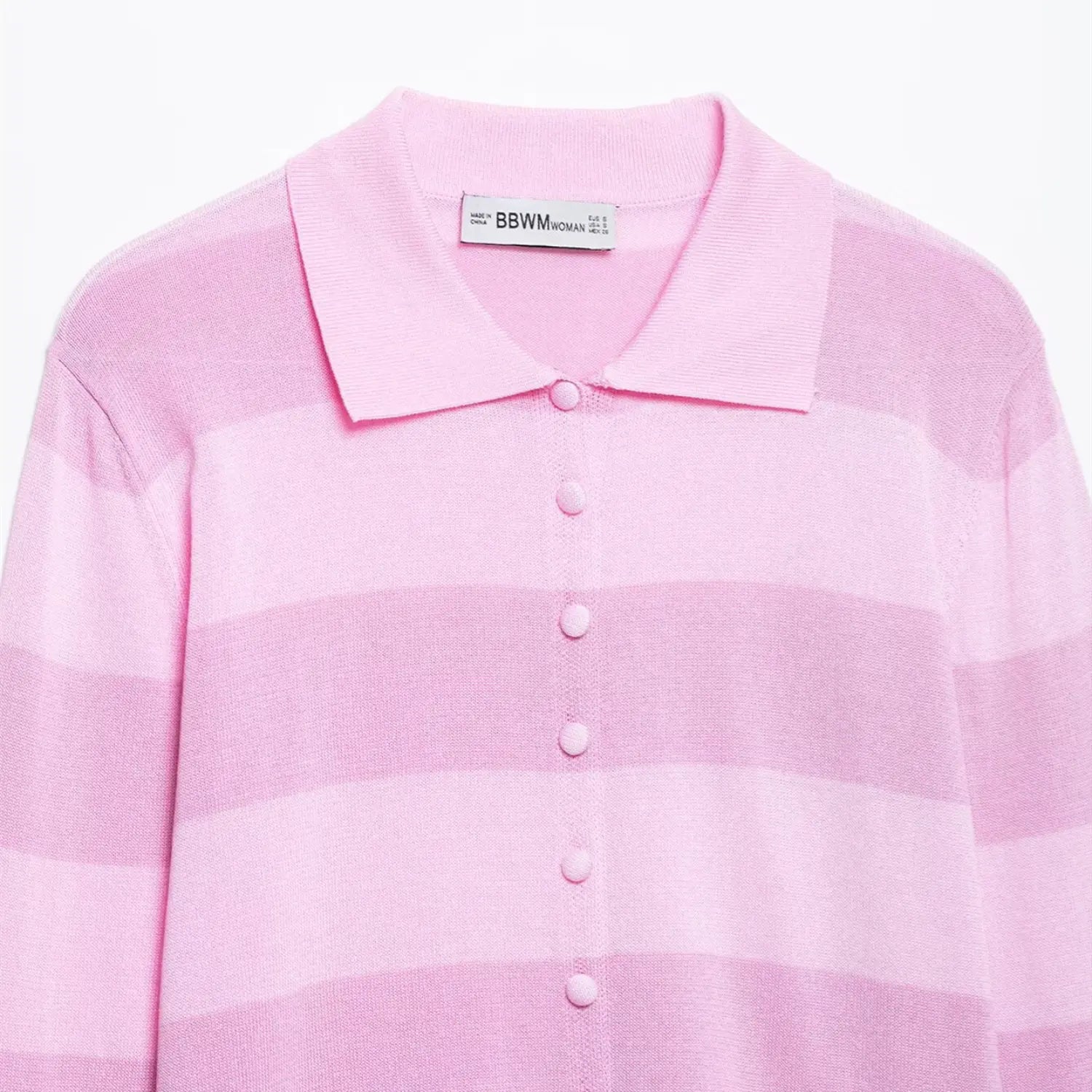 Close-up of the inner brand tag, polo collar, and button placket on the pink striped knit cardigan
