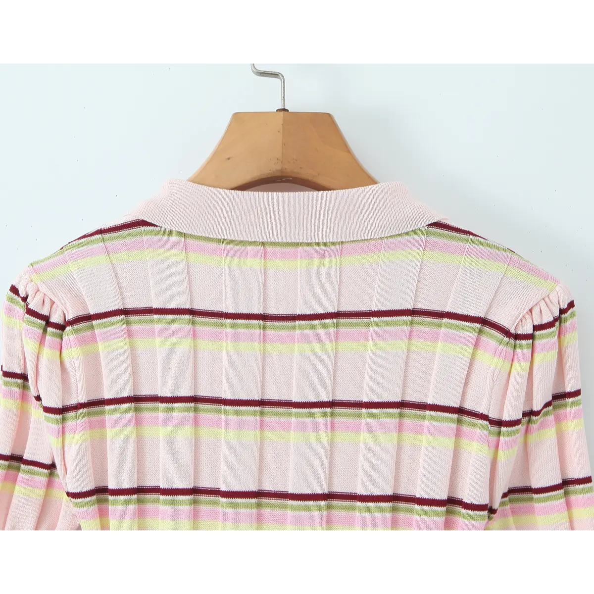 Back view of the pink striped knit polo, showing the ribbed polo collar, vertical ribbing, and gathered shoulder puff detail