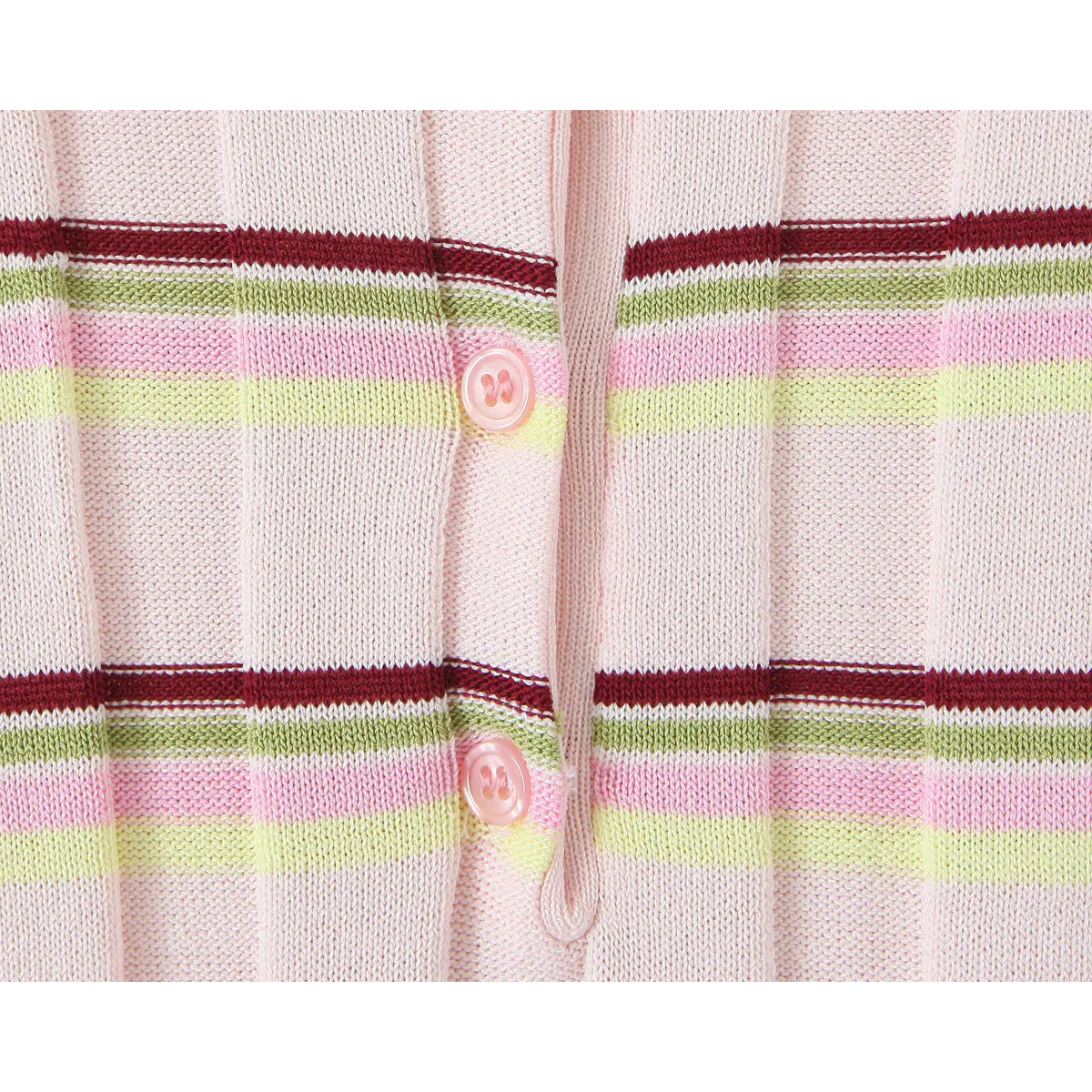 Close-up of the button placket on the pink knit polo, showing the pastel pink buttons and vertical ribbed texture