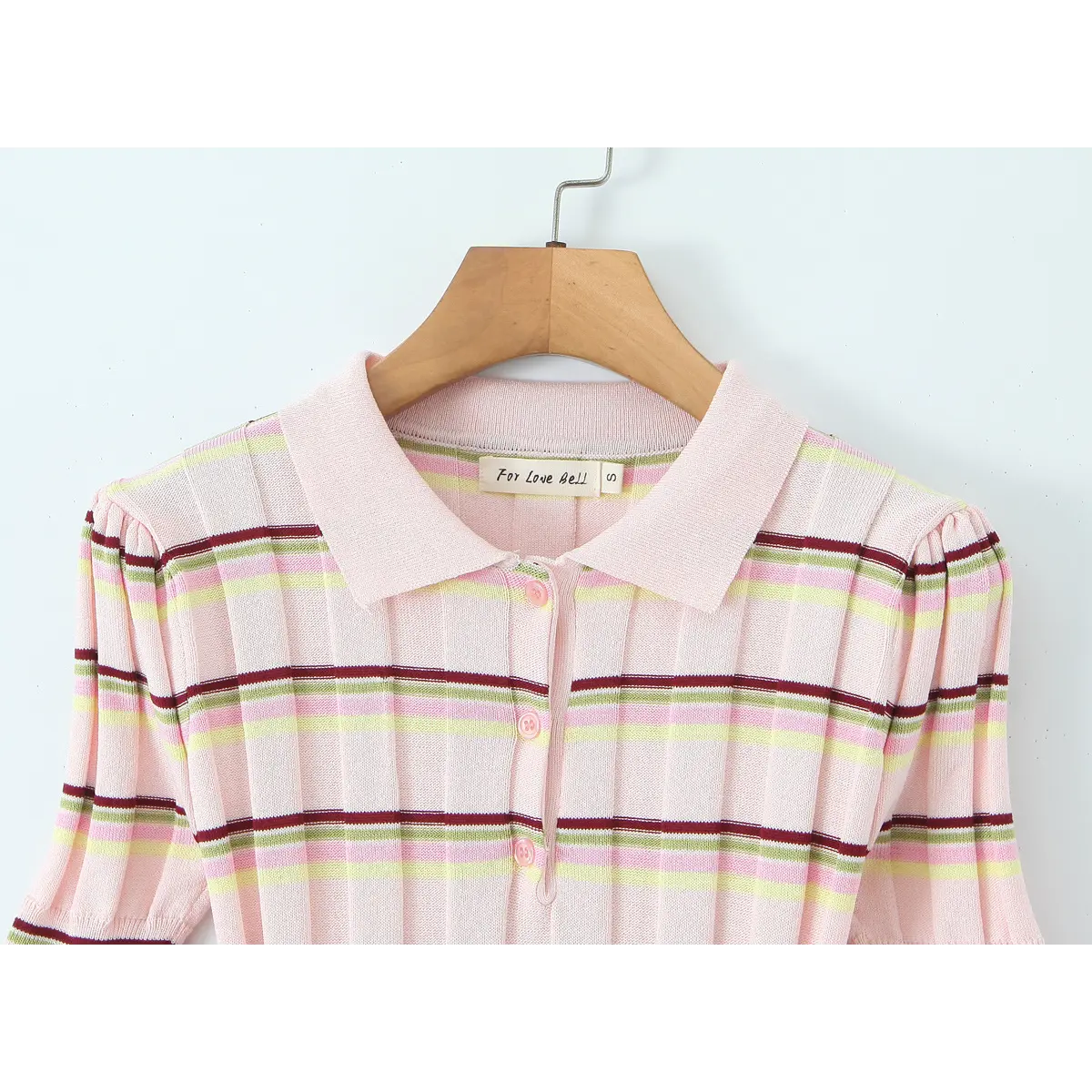 Front view of the pink striped knit polo top, showing the polo collar, button placket, gathered puff sleeves, and "For Love Bell" brand label