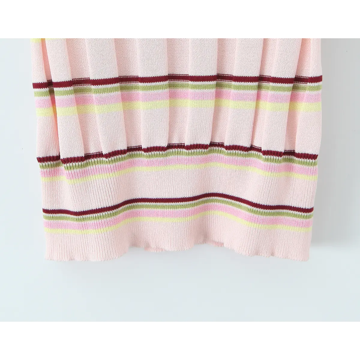 Hem view of the pink striped knit polo, showing the ribbed hemline and layered stripe pattern