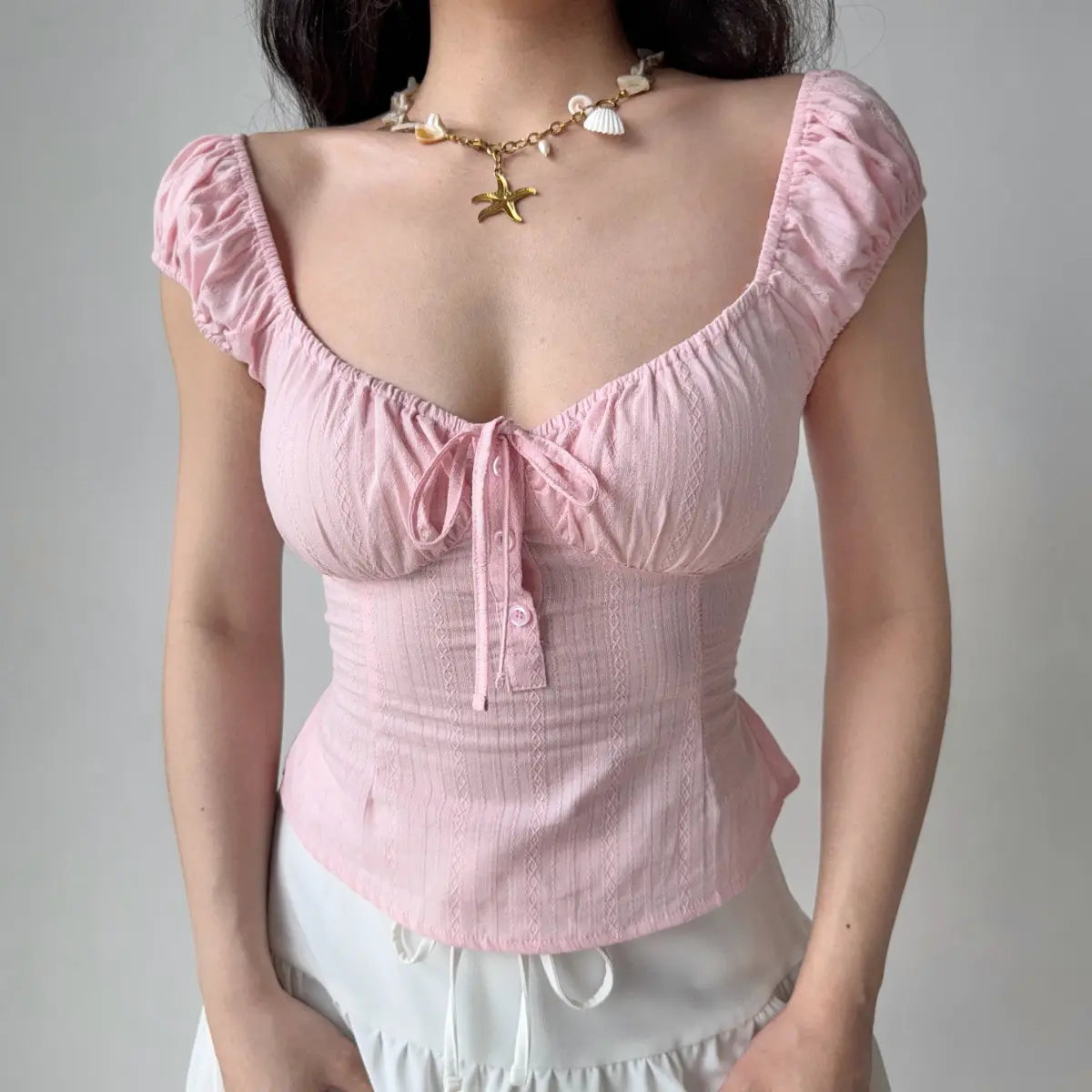 Front view of the same top, showing the sweetheart neckline, center tie detail, and button placket.