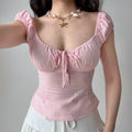The top styled with a gold seashell and starfish necklace, highlighting the neckline.