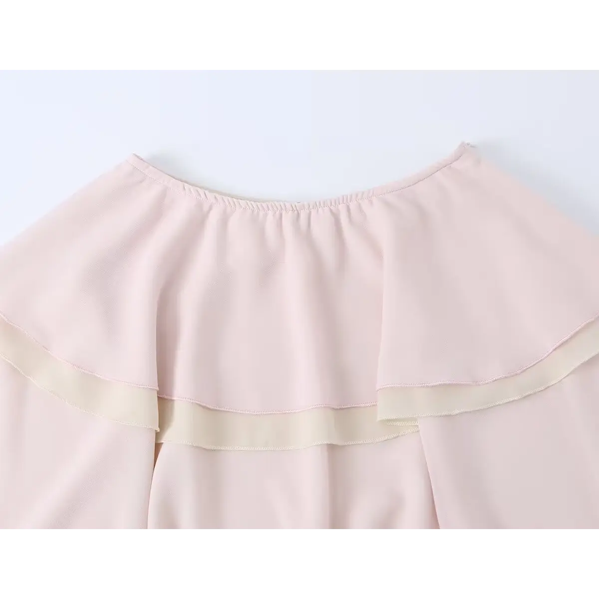  Close-up of the elasticated waistband on a pink tiered chiffon skirt, showing the gathered construction.