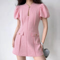 Lifestyle full-body outfit photo of model wearing pink tweed cheongsam mini dress with puff sleeves, paired with gray heart-shaped shoulder bag