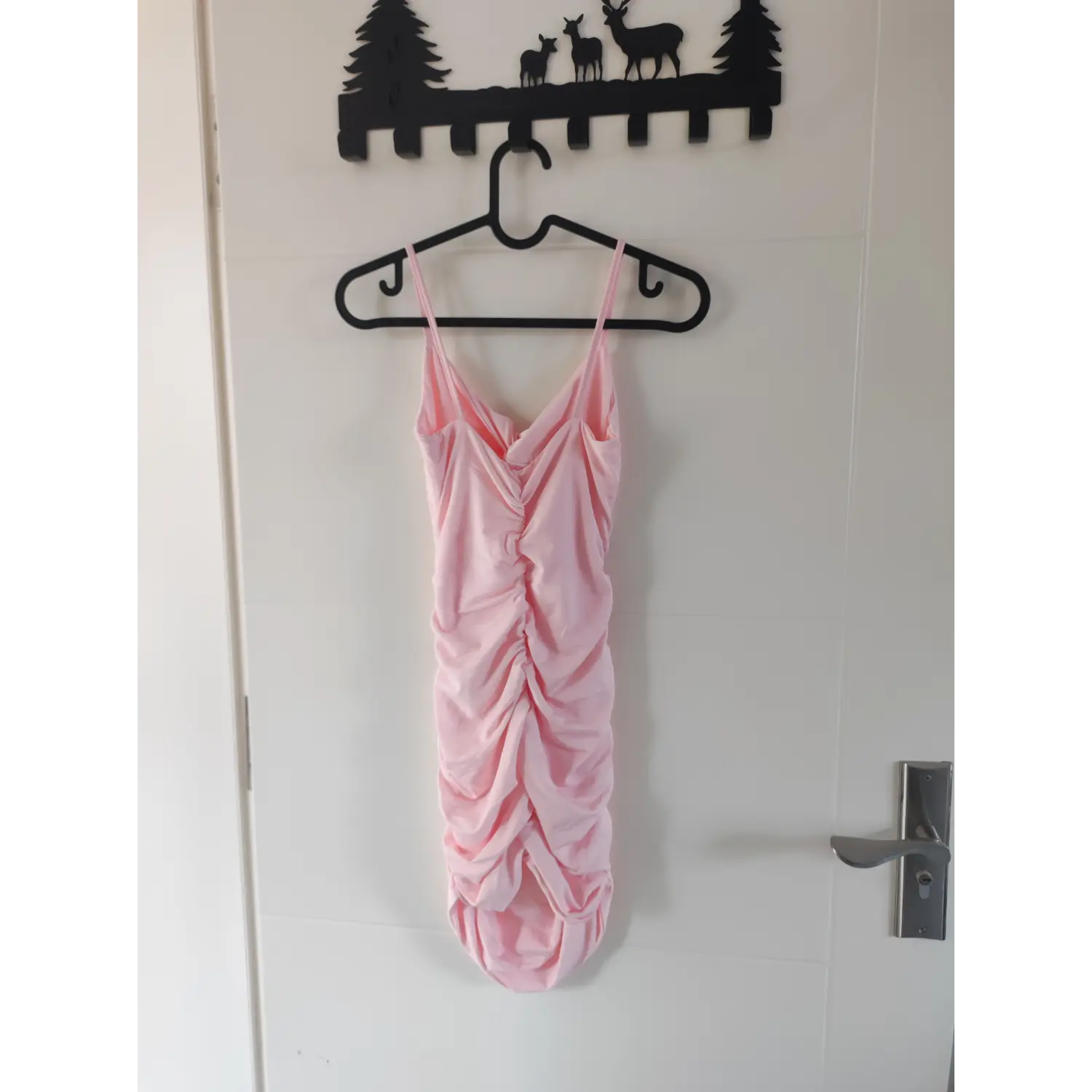 Full back hanging view pink spaghetti strap ruched bodycon mini dress on hanger