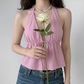 Front lifestyle shot on model of pink vertical stripe halter cami top, V neck, front drawstring tie waist, sleeveless cropped vacation blouse