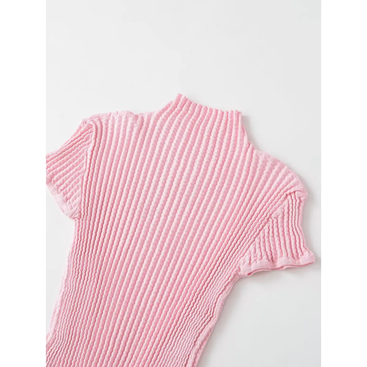 Back view of the pink waffle-knit top, showing the mock neck and short sleeves