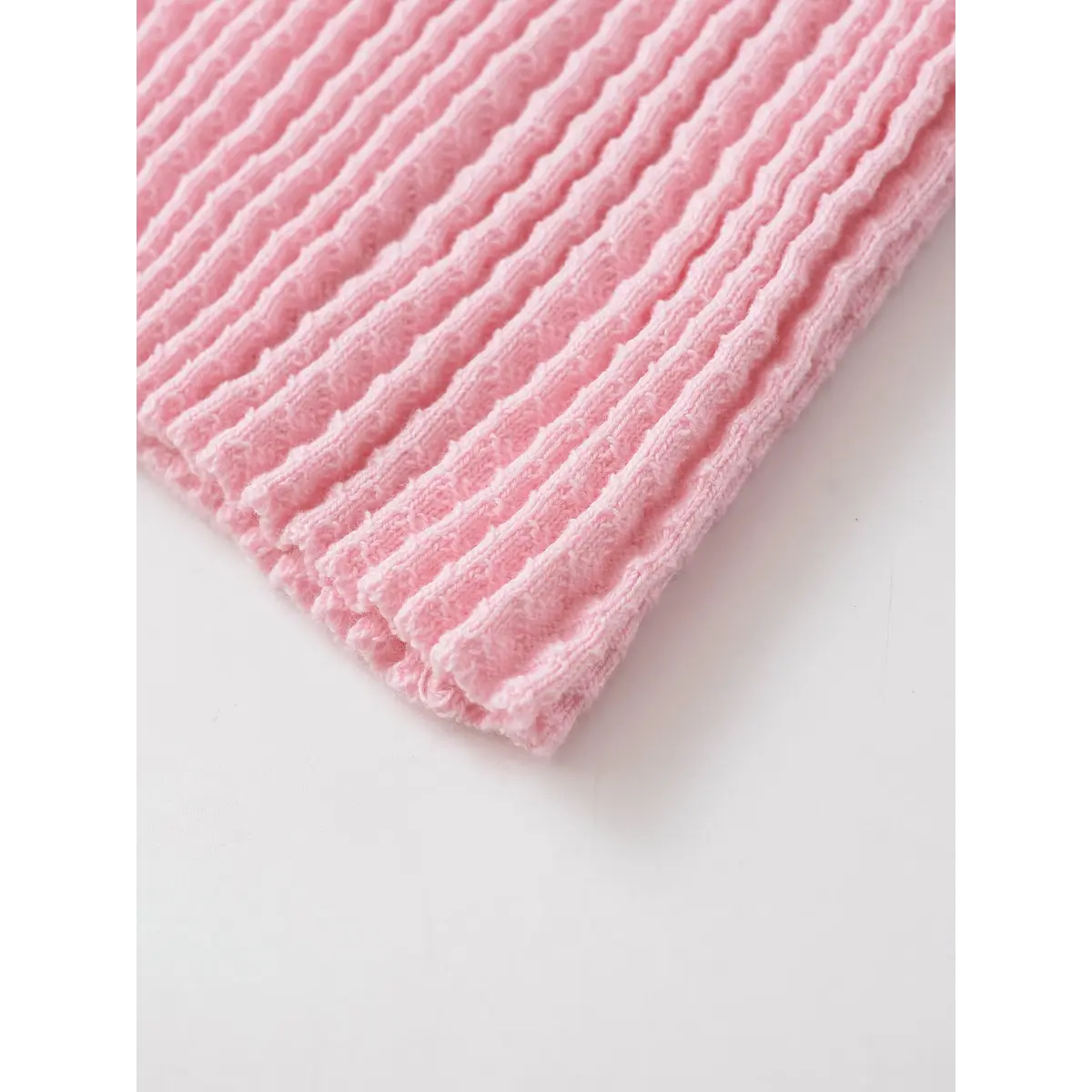 Close-up of the pink waffle-knit fabric, showing the textured ribbed pattern and soft finish