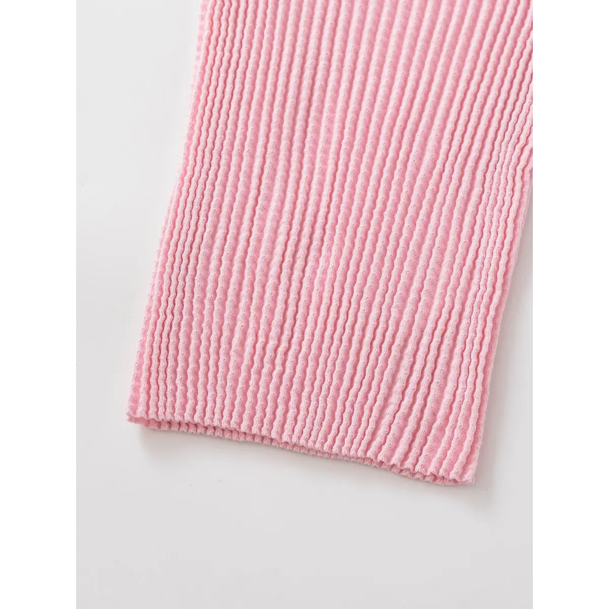 Close-up of the pink waffle-knit hem, showing the detailed ribbed texture