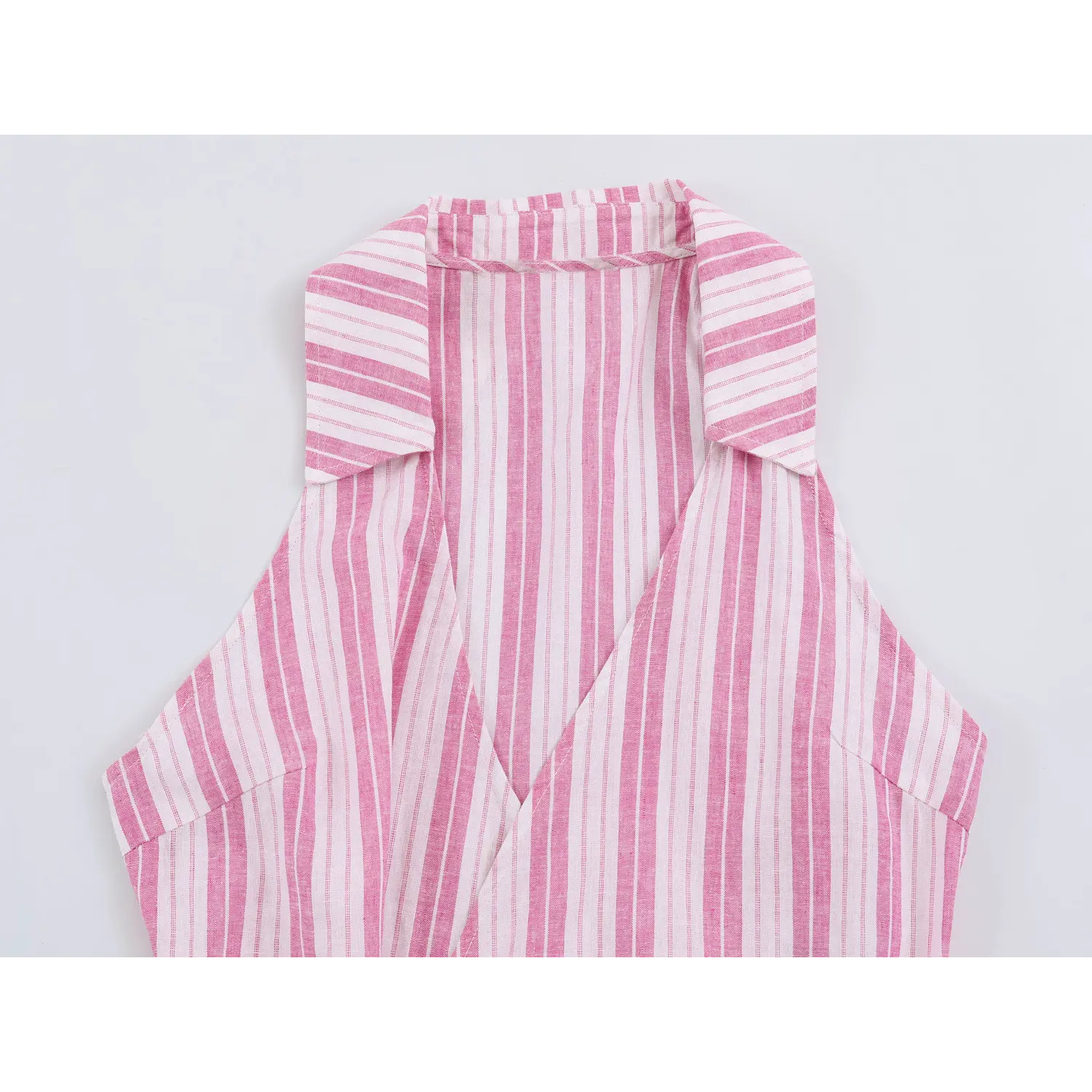 Partial close-up of halter lapel collar and deep wrap v-neck on pink vertical stripe sleeveless top
