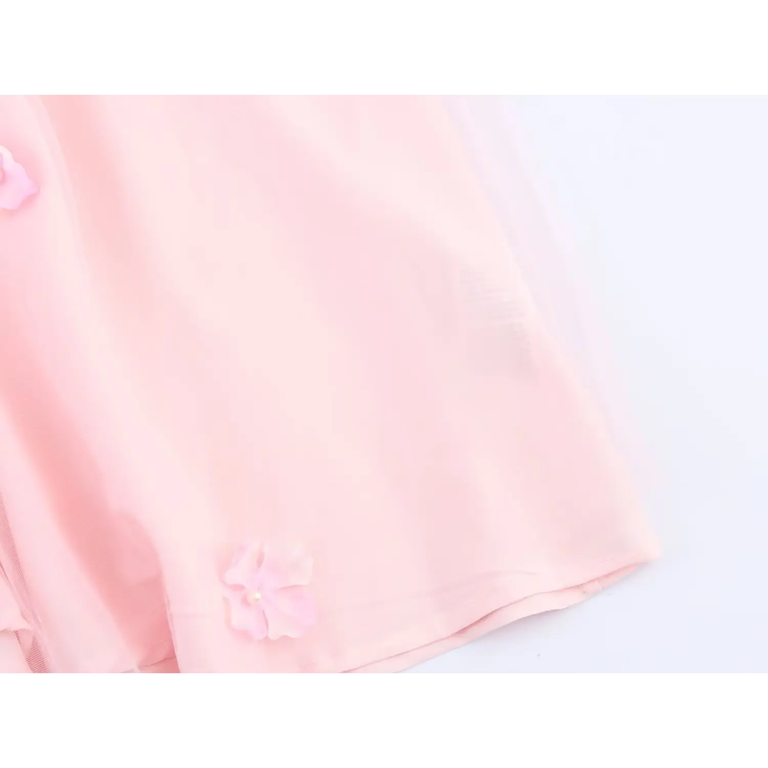 Close‑up of pink tulle fabric and 3d flower detail