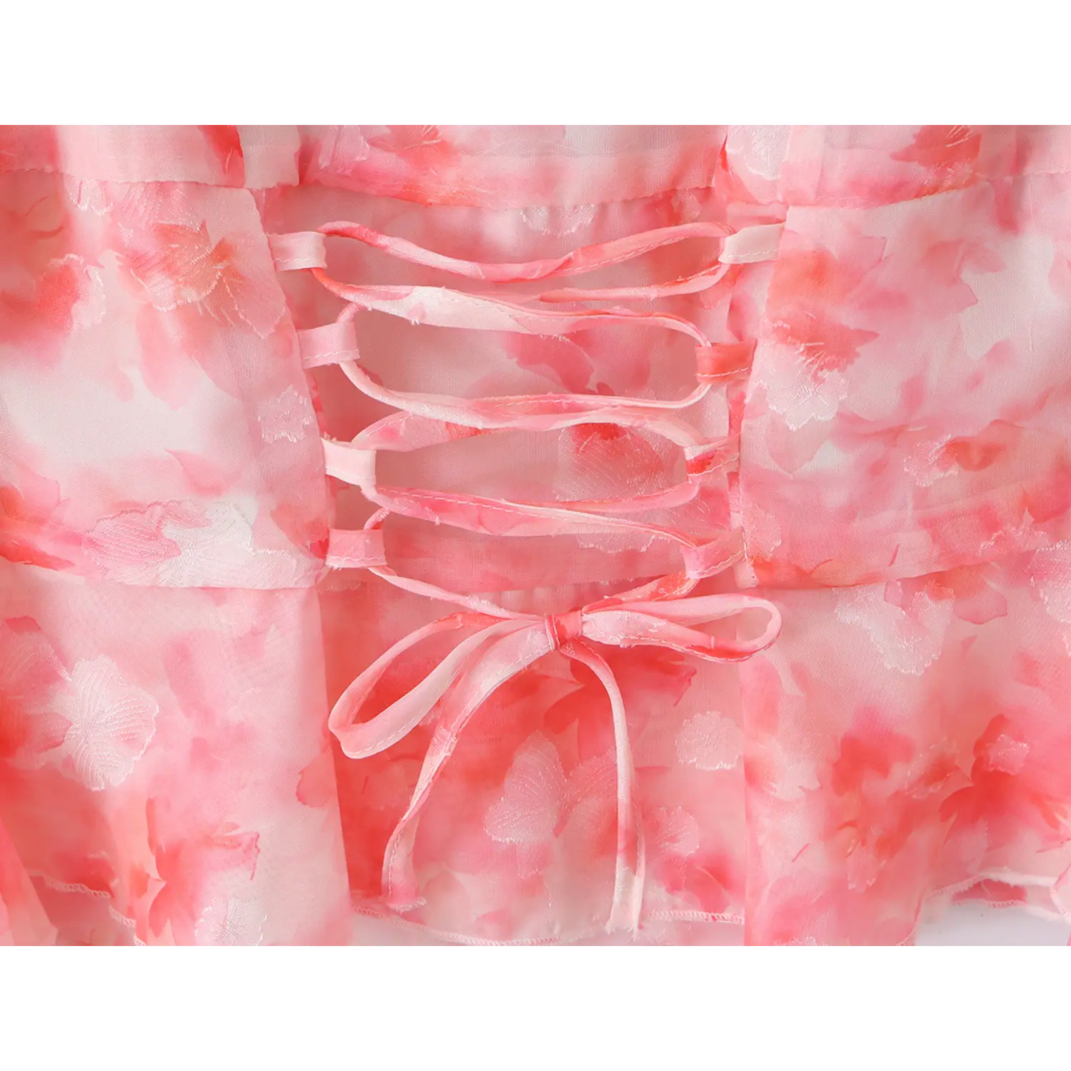 Close‑up of back corset lace‑up tie detail, adjustable pink fabric laces with bow, floral chiffon panels