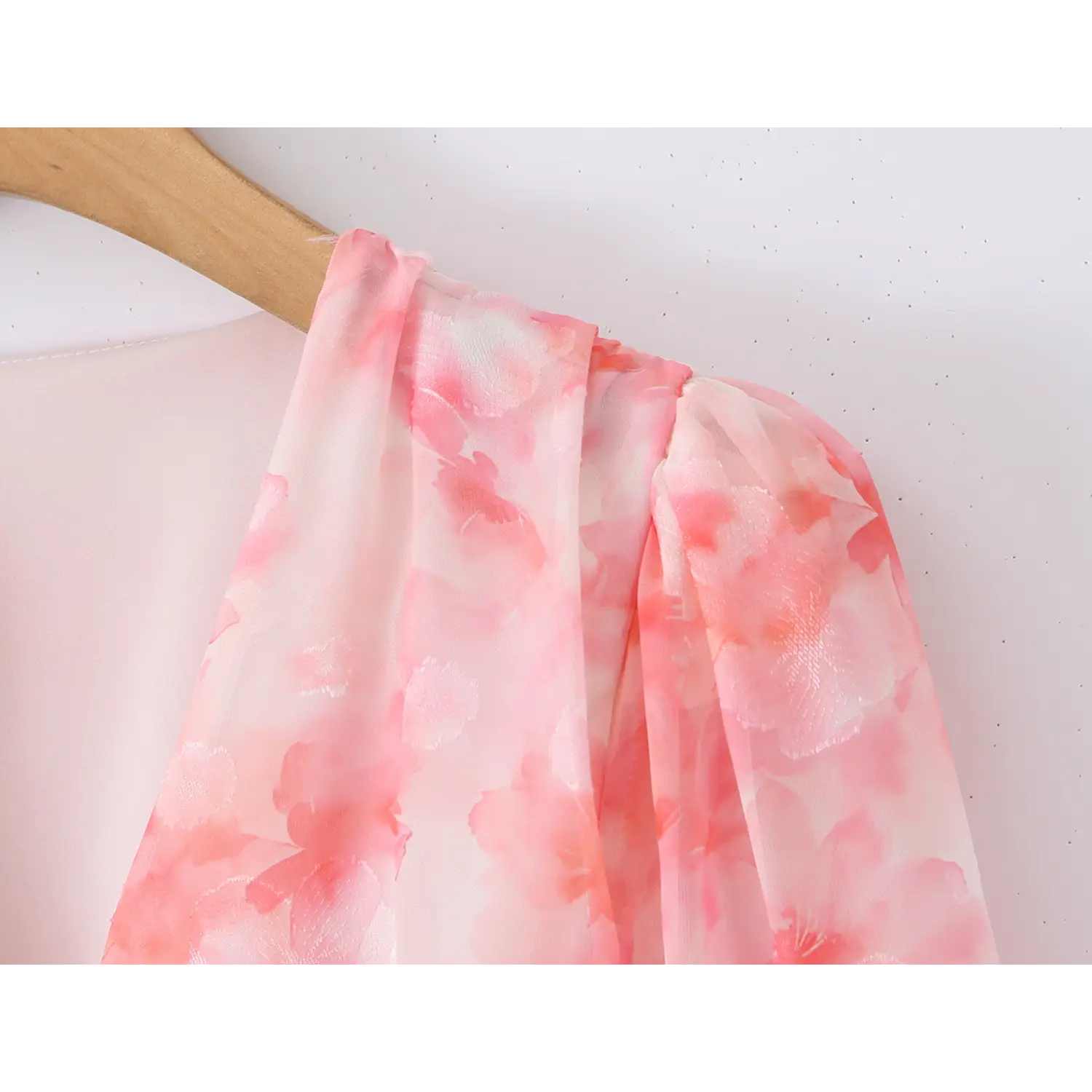 Macro shot of gathered puff shoulder seam, pink floral jacquard chiffon, soft flowy fabric texture
