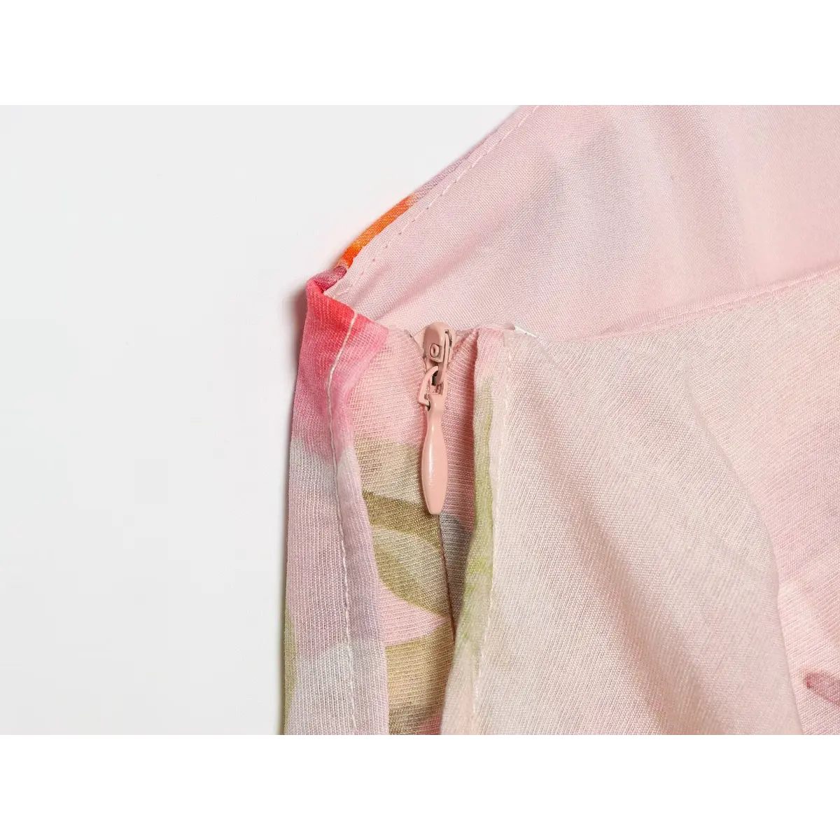 Close‑up of invisible back zipper on pink floral one‑shoulder maxi dress