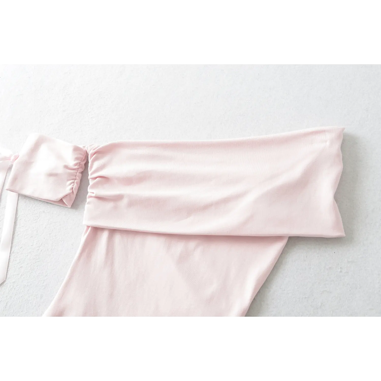 Wide fold over off shoulder bandeau neckline flat lay detail matching pink bow sleeve