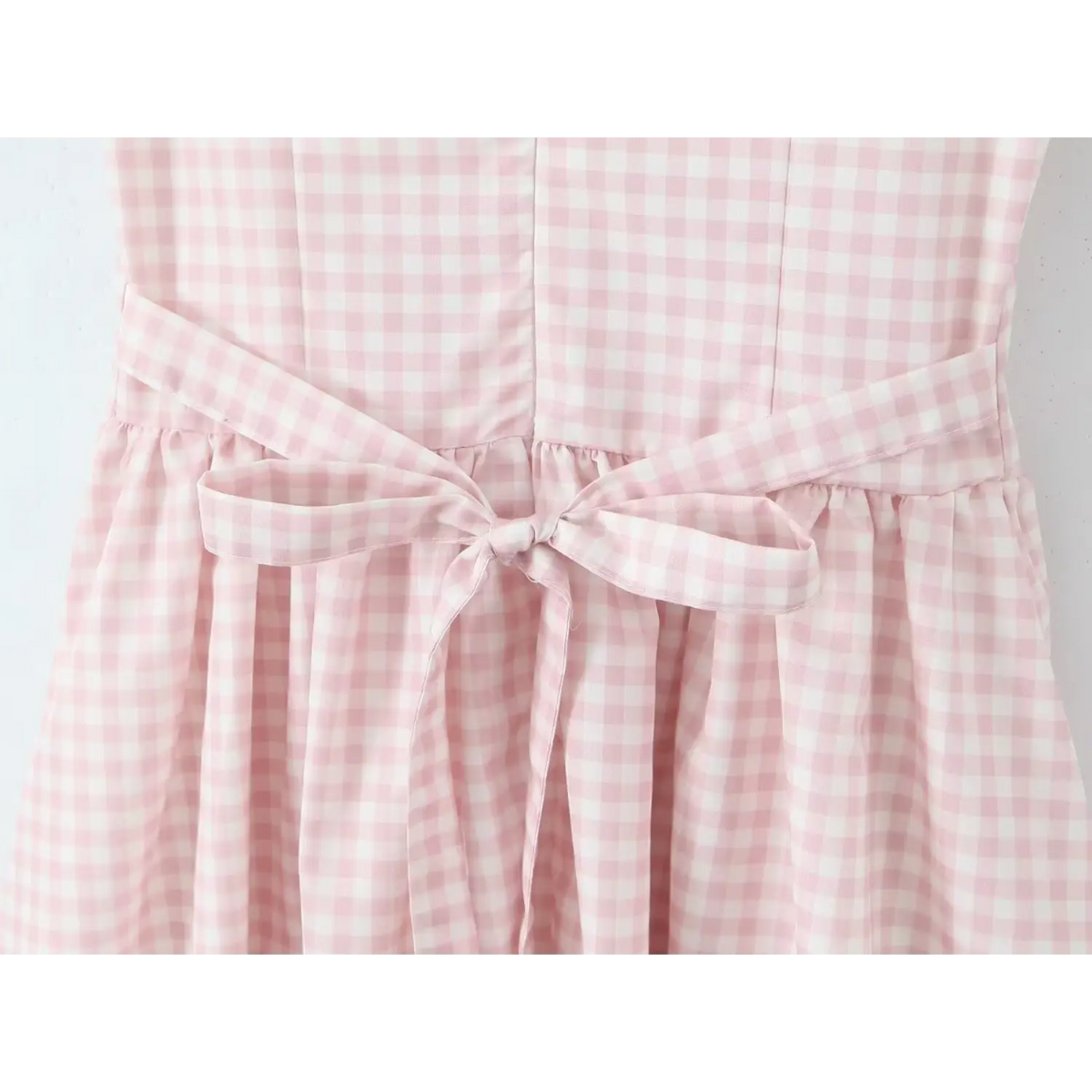 Close‑up of fabric tie bow at back waist for gingham maxi dress
