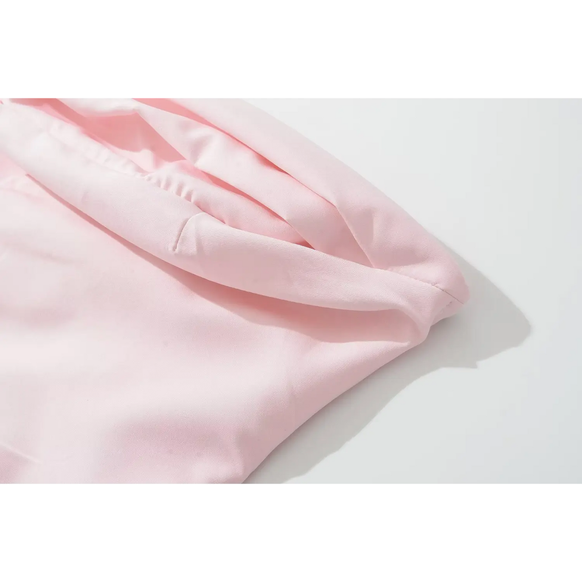 Close‑up of folded halter collar fabric detail in pink