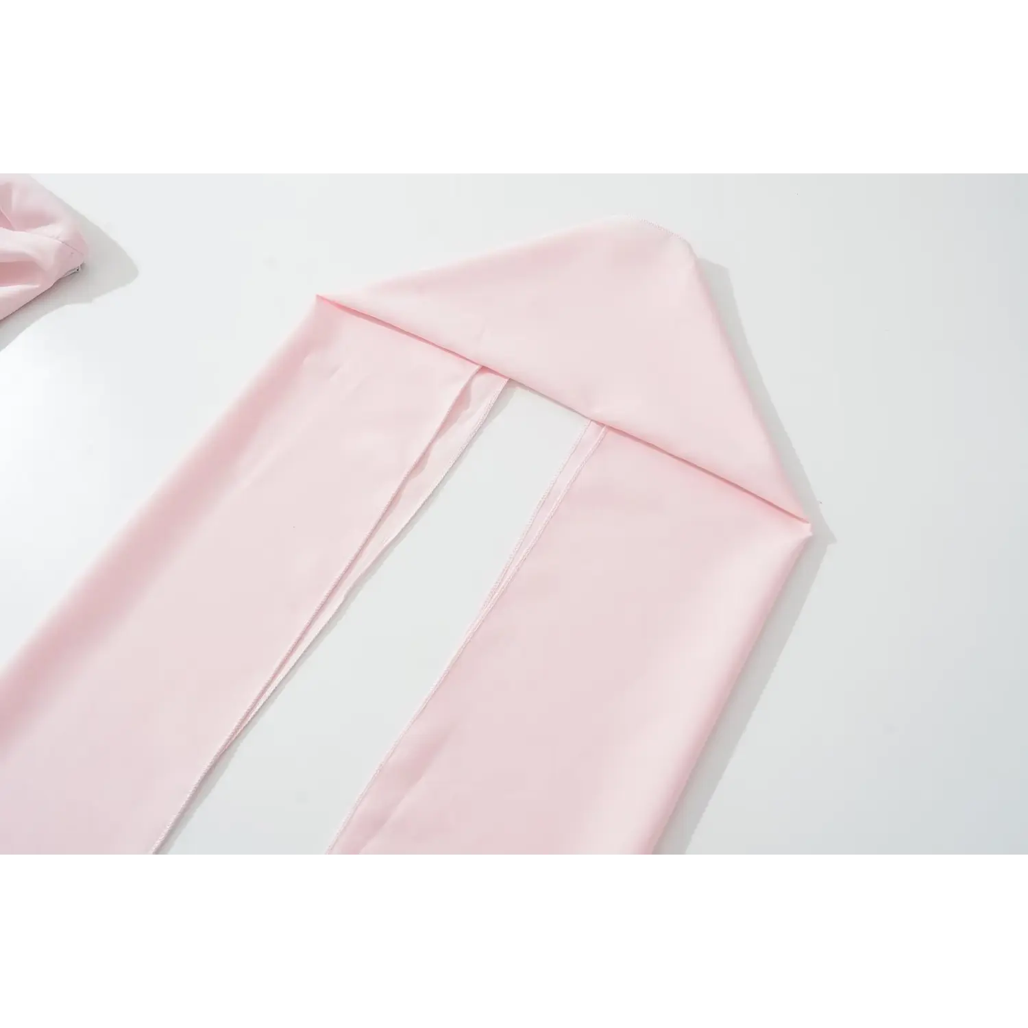Flat lay close‑up of separate pink matching long sash accessory