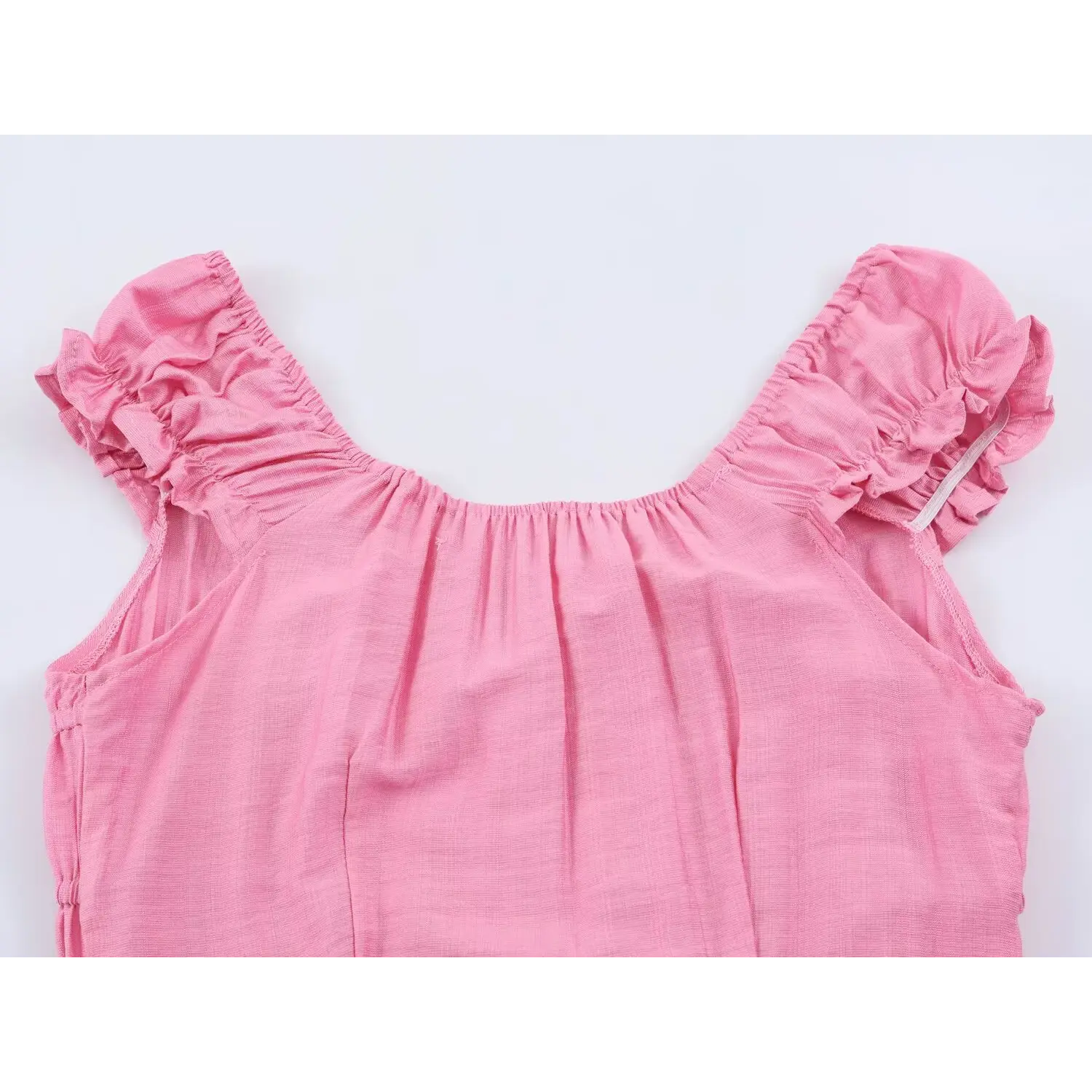 Partial flat shot of square ruffle neckline and cap sleeves