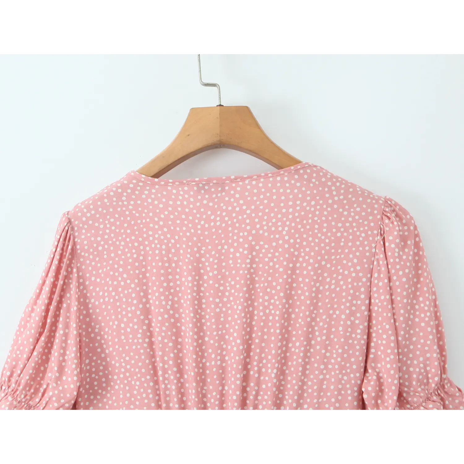 Close‑up of gathered back bodice of hanging pink polka dot dress