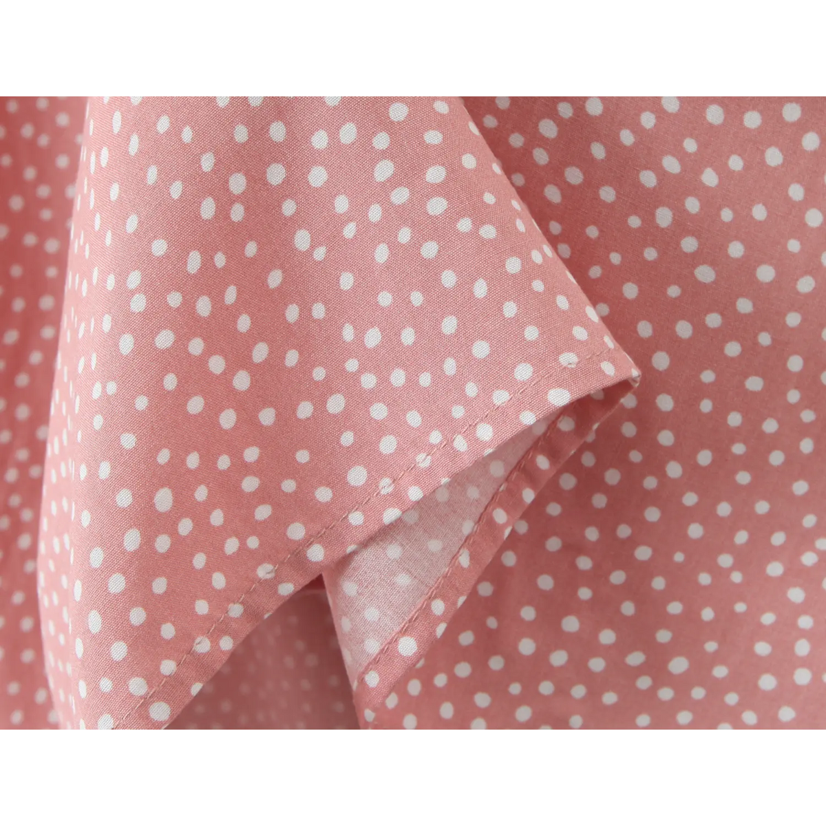 View of flowy skirt hem, pink white polka dot maxi dress