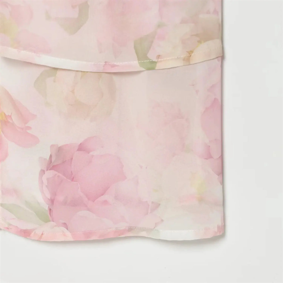 Partial view of ruffled skirt hem with watercolor floral print