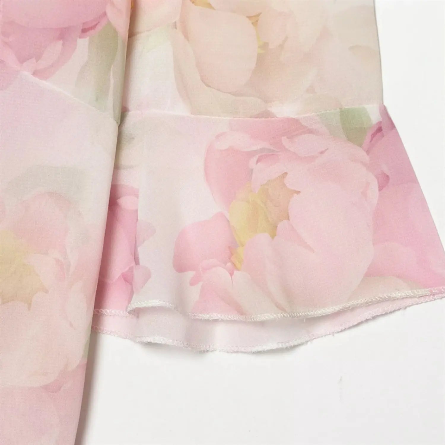 Close‑up of flutter sleeve ruffled hem and floral fabric