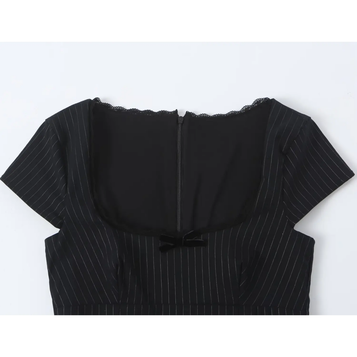 Close-up of square neckline, black bow, lace trim and back zipper