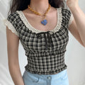 Model wearing vintage y2k black white check cropped blouse, eyelet lace square neck with black satin bow, elastic smocked waist, paired with light blue jeans, sweet casual streetwear outfit