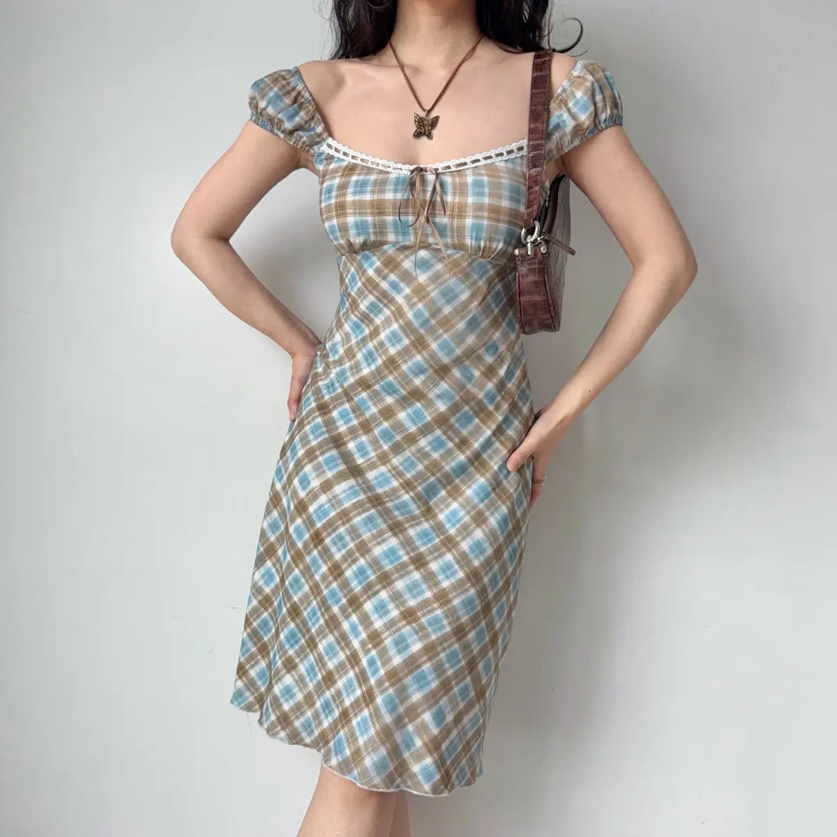 The blue-brown plaid midi dress styled with a brown crocodile-pattern shoulder bag.