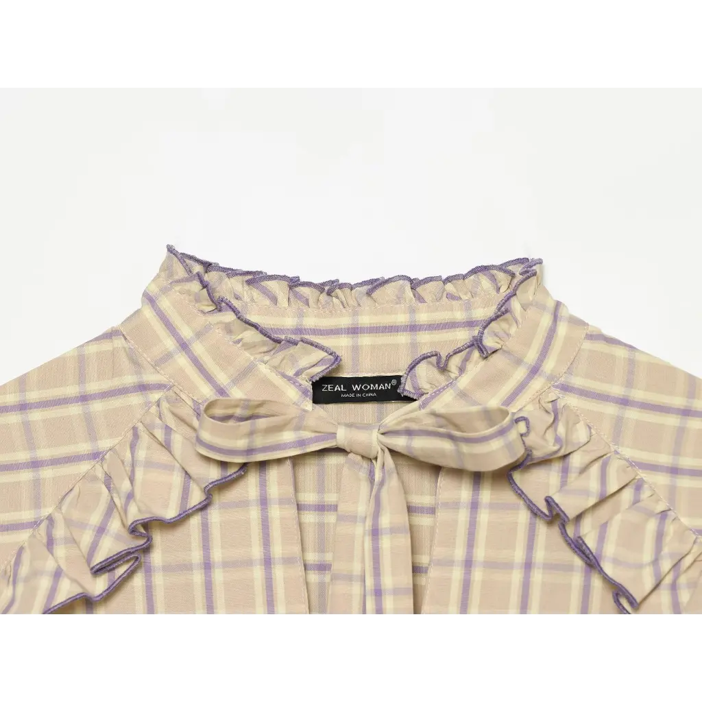 Close-up of ruffled mock neck, bow tie and inner label