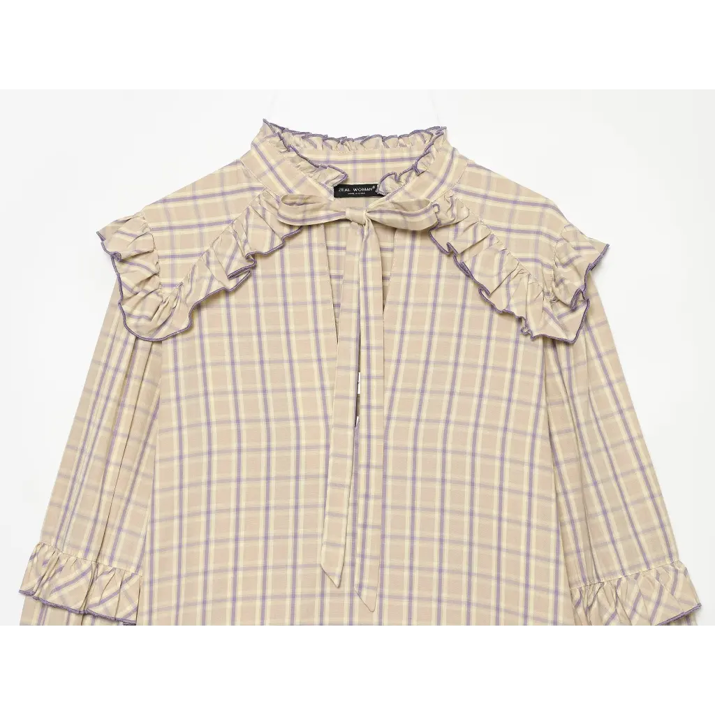Close-up of tie neck bow and ruffled shoulder