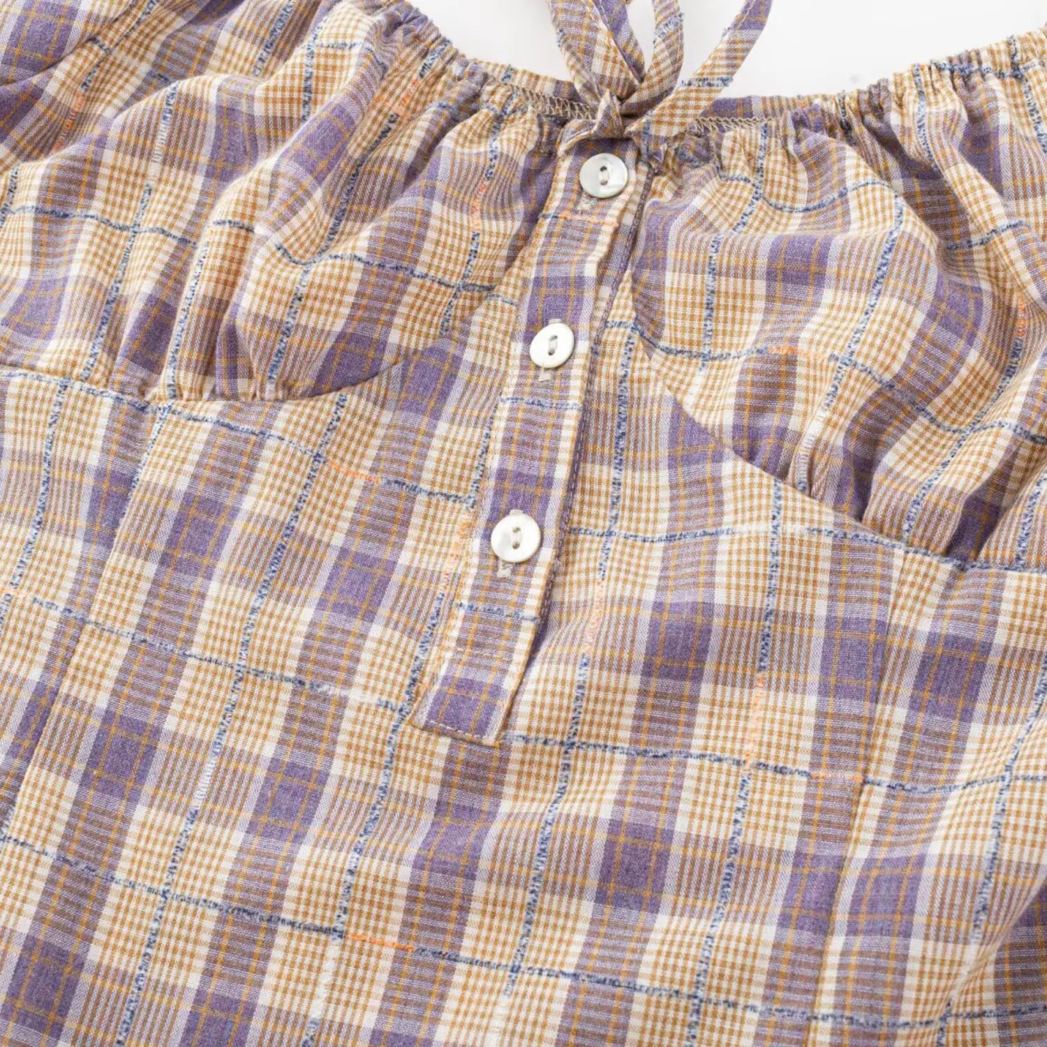 Purple yellow plaid top bust close-up, half open white round buttons and adjustable front drawstring woven fabric detail