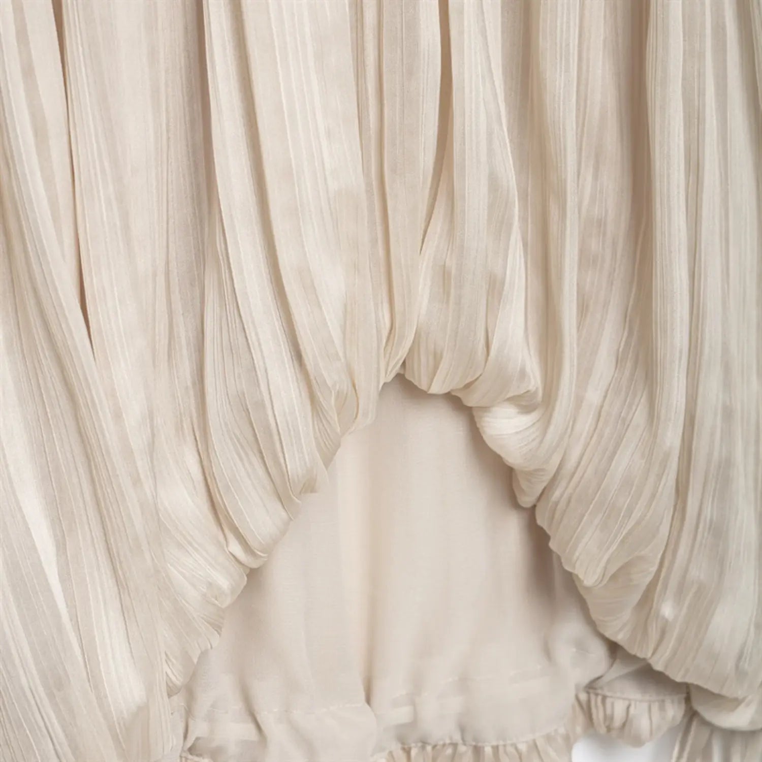 Mid-lower shot of loose pleated outer fabric above elasticated bubble hem lining