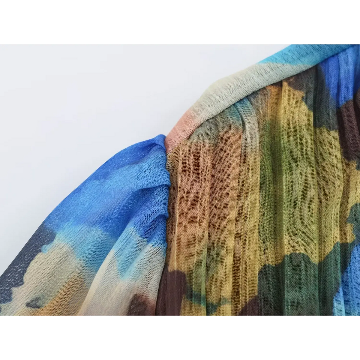 Close-up of balloon sleeve and vertical pleats on multicolor watercolor chiffon maxi dress