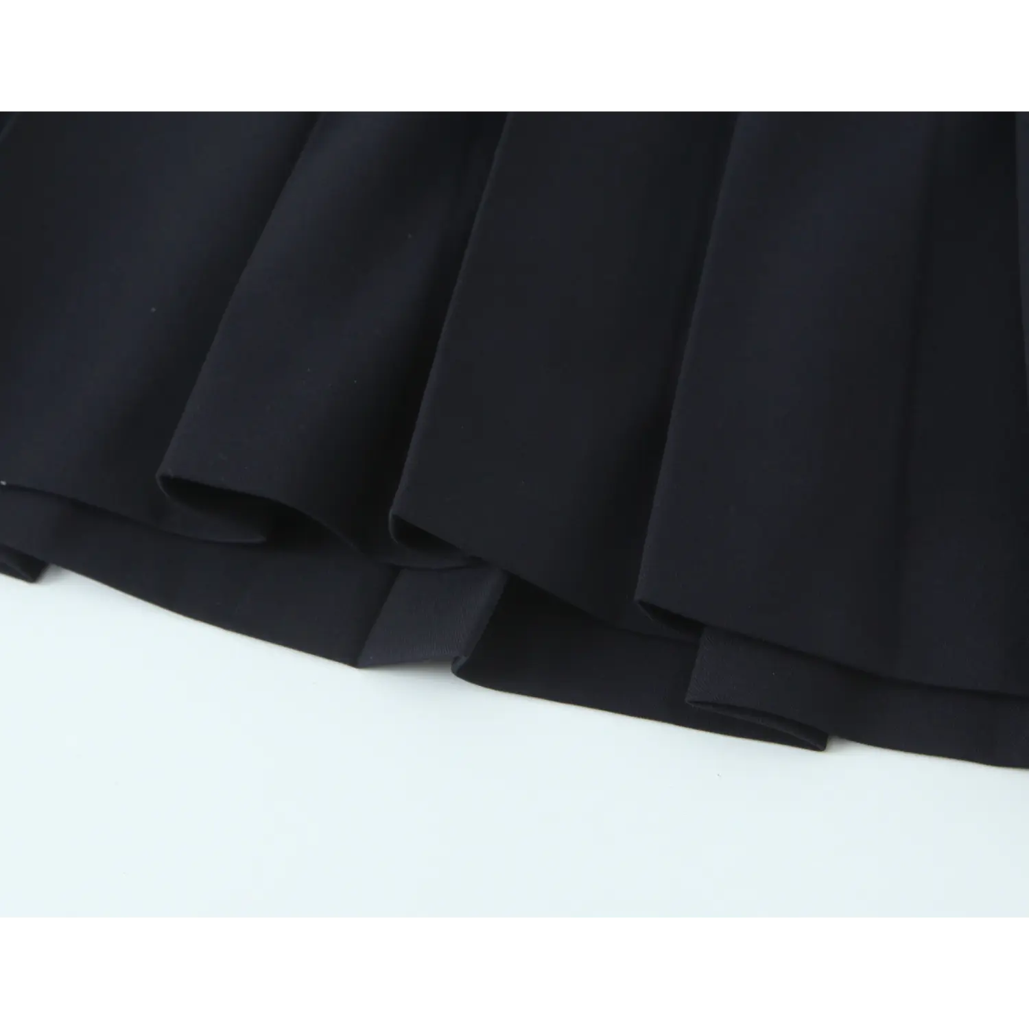Skirt hem close-up, double folded binding edge, neat uniform topstitch, structured wrinkle-resistant suiting material