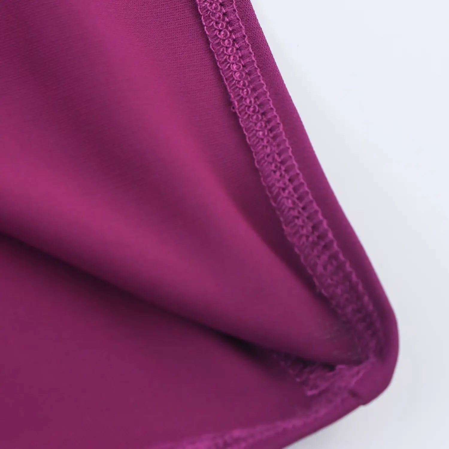 Close‑up view of plum halter midi dress, fine overlock seam stitching fabric detail