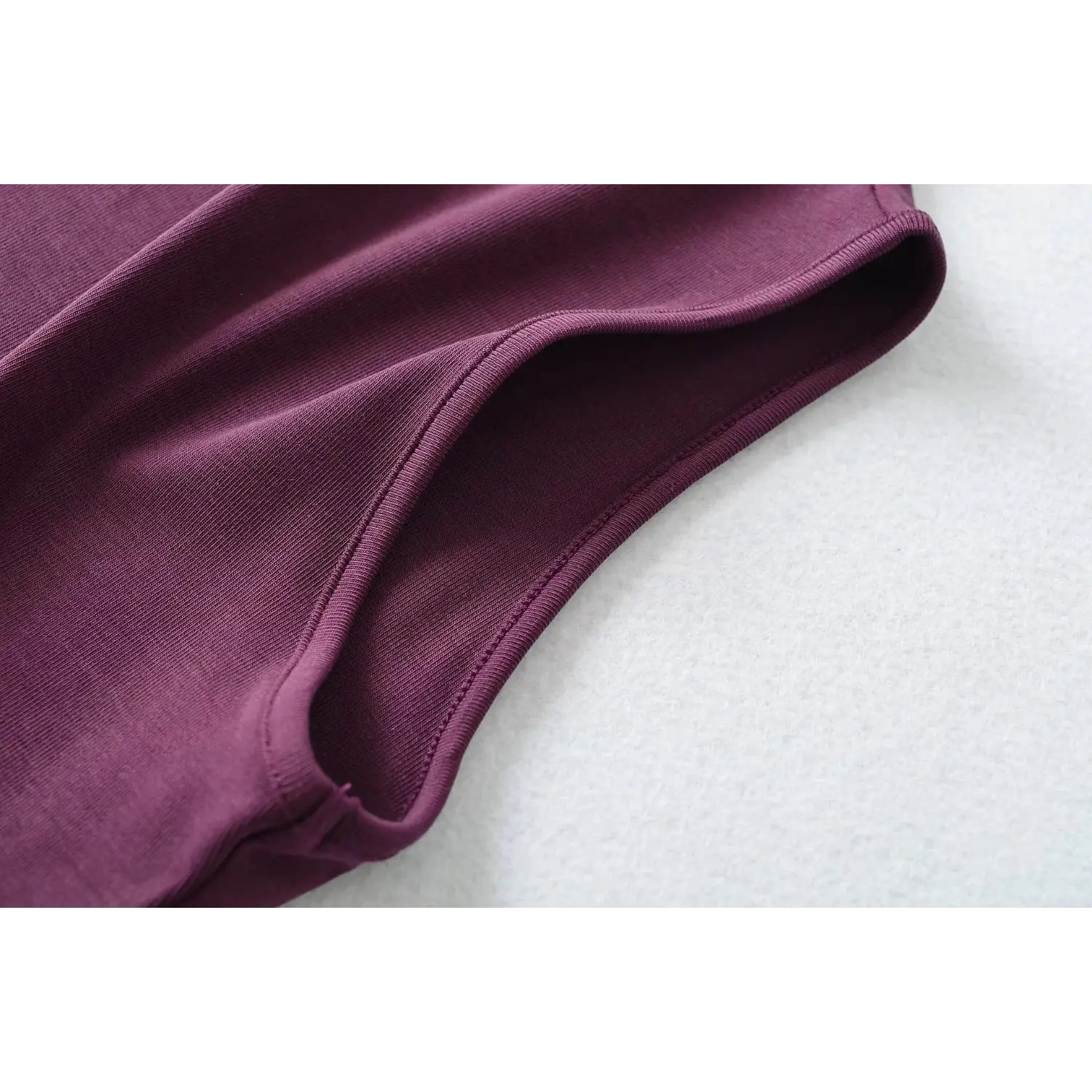 Armhole detail closeup, plum sleeveless turtleneck tank top, neat finished edge stitching