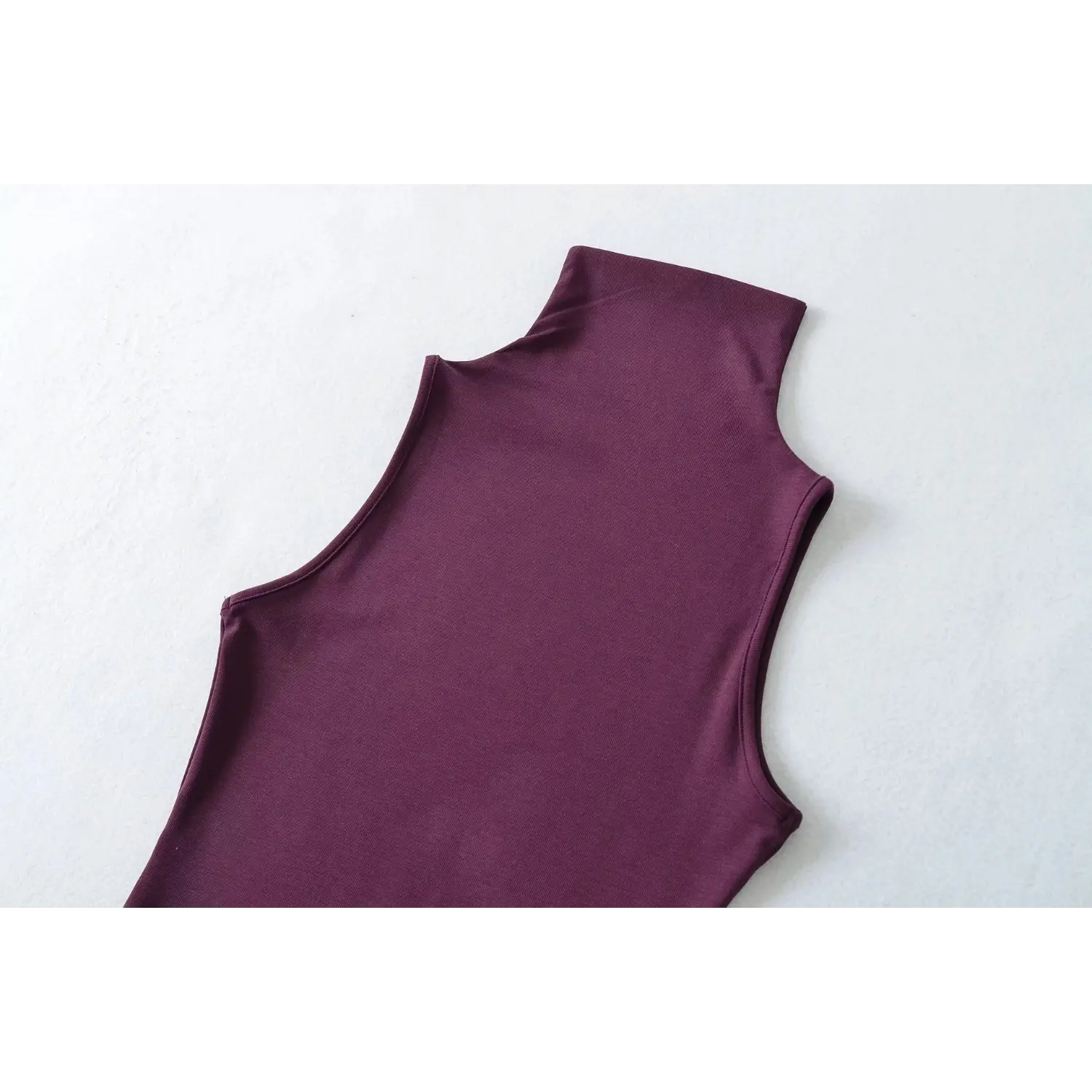 Partial back side detail shot, plum sleeveless turtleneck tank top, display back silhouette and armhole
