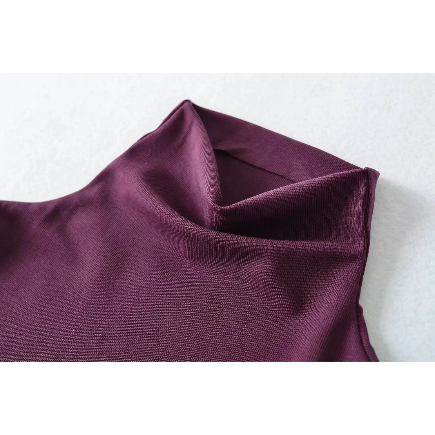 Collar closeup shot, plum sleeveless turtleneck tank top, foldover high neck design