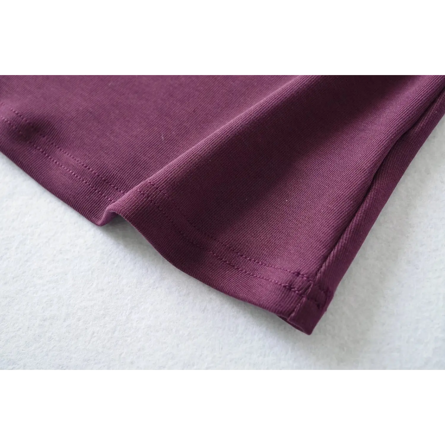 Hem stitching closeup, plum sleeveless high neck tank top, fine double stitching craftsmanship
