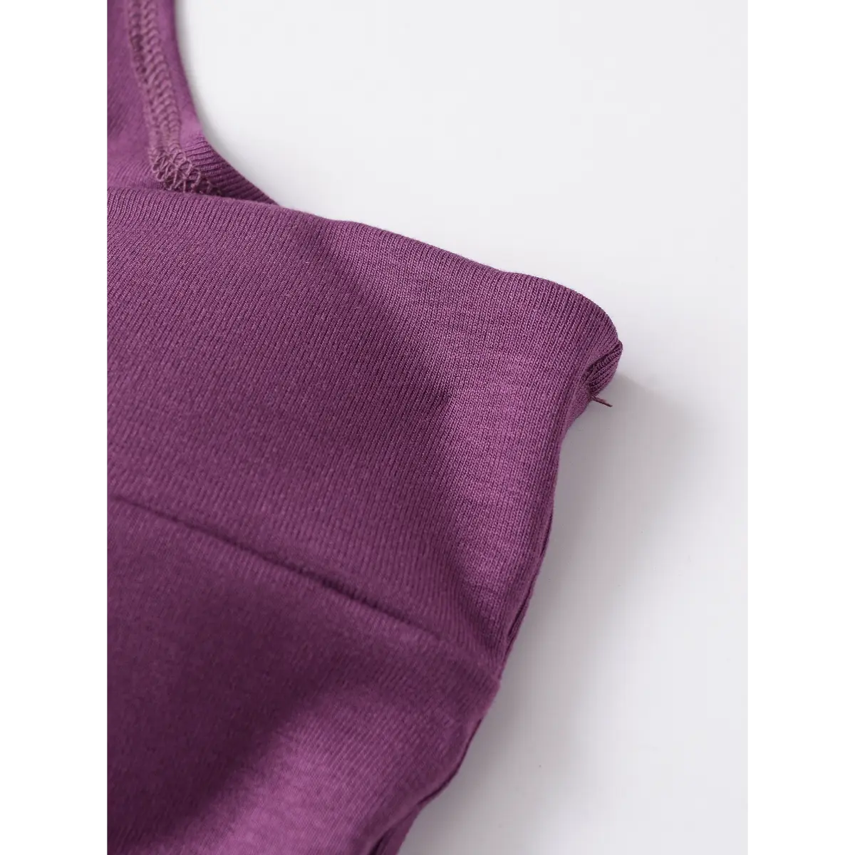  Close-up of the structured bust seam and smooth knit fabric on the plum halter top.