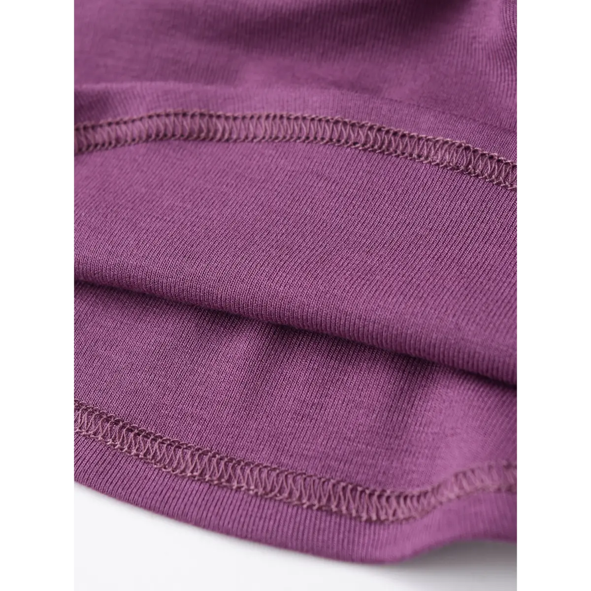 Close-up of the neat zigzag stitch hem on the plum-colored halter top.
