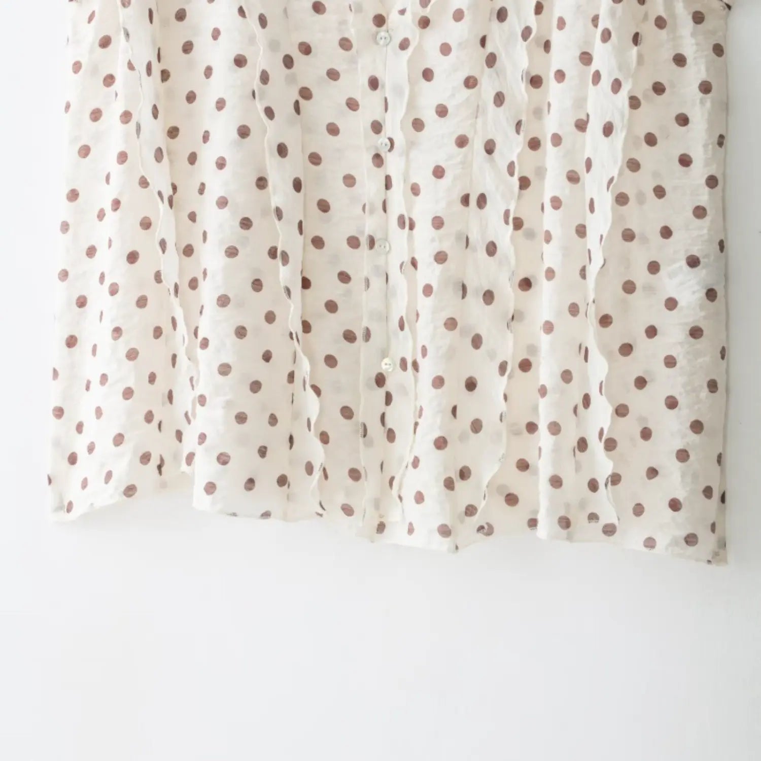 Vertical shot of front button row, lettuce trim extending down entire placket to bottom hem
