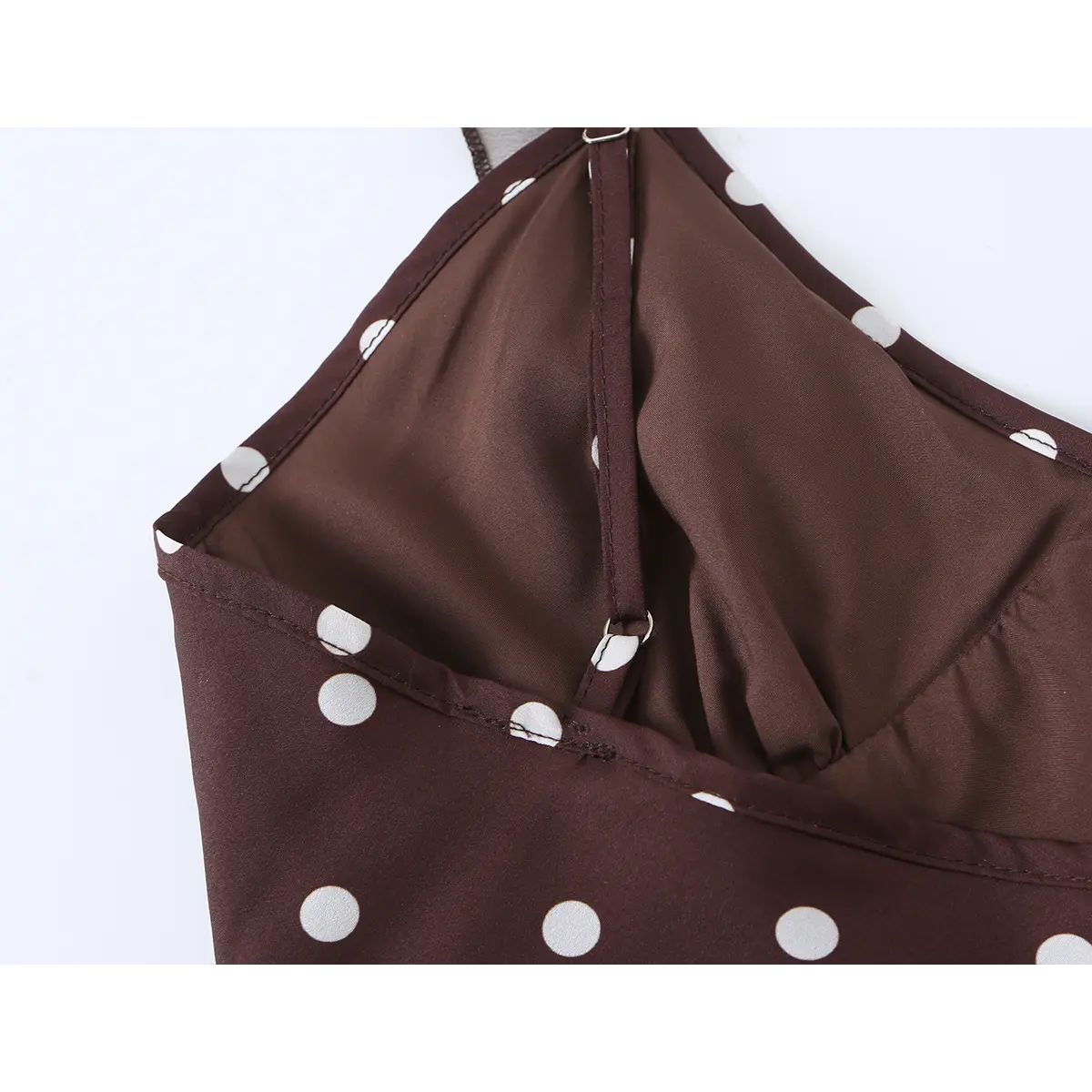 Close-up view of the inner strap and lining of brown polka dot dress, showing adjustable strap design and neat stitching.