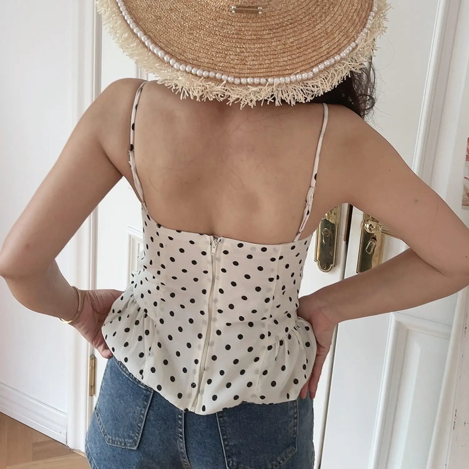 Black dot cream chiffon cami waist close-up, vertical boned panels and peplum ruffle polka dot printed fabric flat lay detail