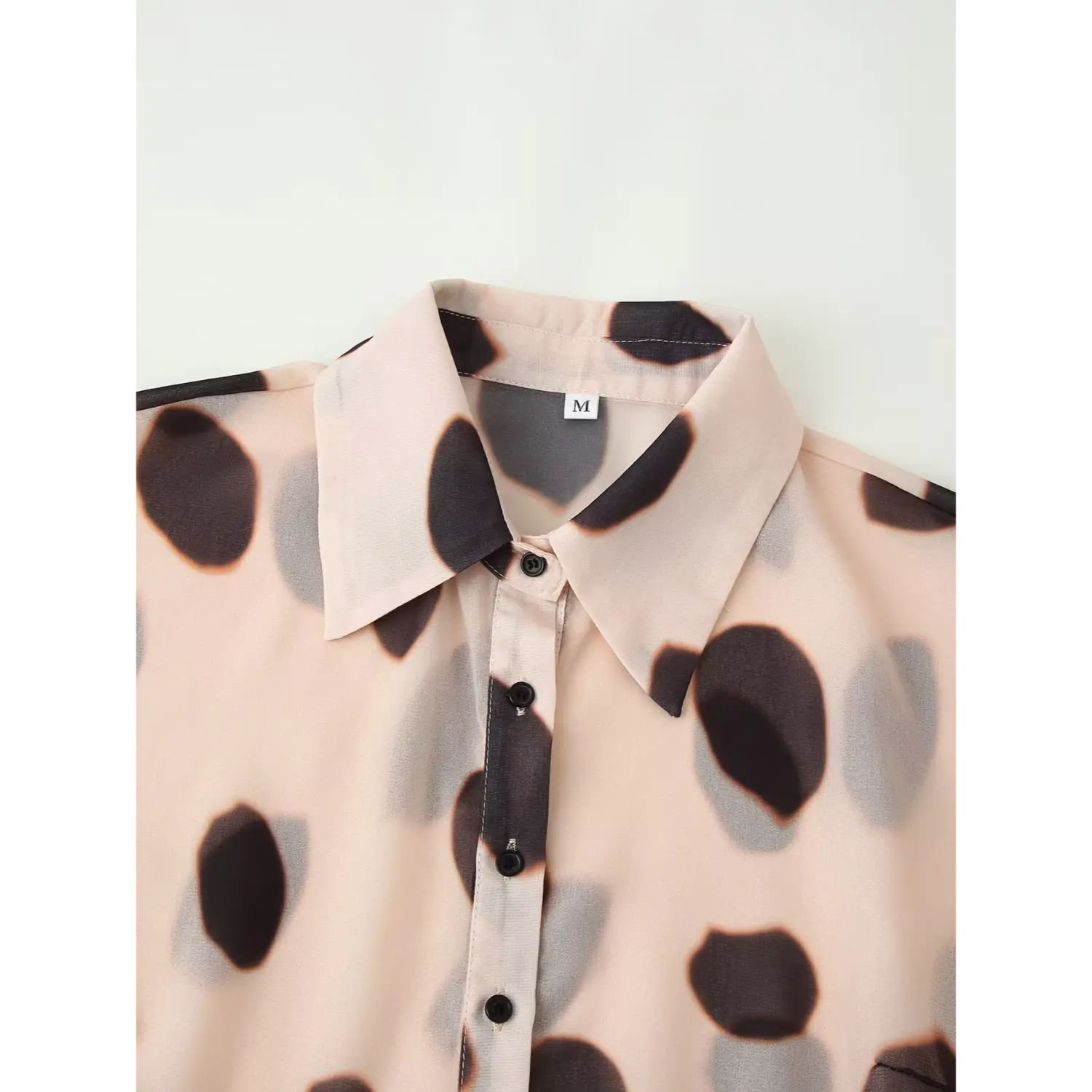 Point lapel collar close up of beige ink spot chiffon blouse, black front buttons inner size label detail