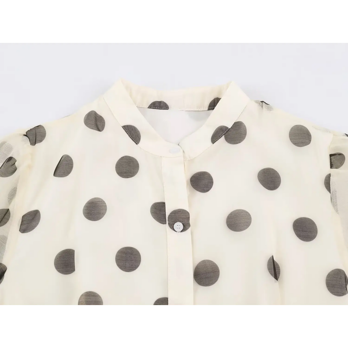 Close-up of stand collar, white buttons and puff shoulder on polka dot dress