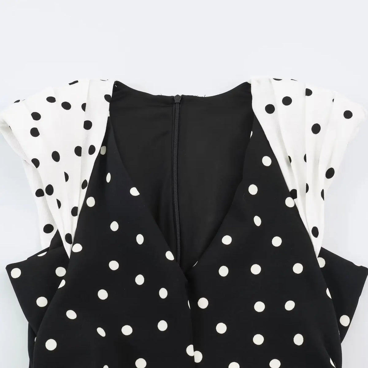 Close‑up of v‑neck, contrast pleated cap sleeves and back concealed zipper